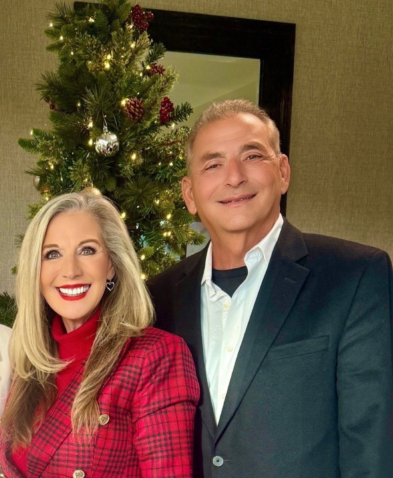 Harry and Cheryl Salem smiling together beside a Christmas tree